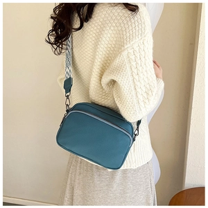 Sac bandoulière en cuir bleu avec une large sangle tissée aux motifs géométriques