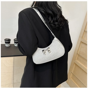 Silver sequin crescent shoulder bag with metallic bow detail on female model
