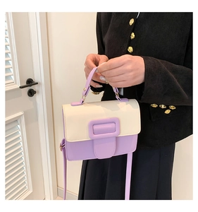 Detail of lavender and cream crossbody bag with large buckle and detachable strap