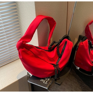 Chic red nylon crescent crossbody bag with minimalist design and woven zipper detail