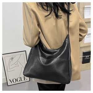 Detailed side view of the black matte PU leather hobo shoulder bag with stitch seams