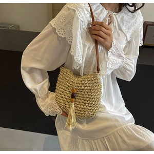 Detail der handgewebten Strohtasche mit langen Fransen, Holzperlen und Lederriemen
