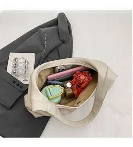 Spacious interior of a cream PU leather tote bag showing items like a tablet and umbrella