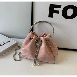 Pink velvet drawstring bucket bag with sparkling rhinestone handle and elegant pearl charm