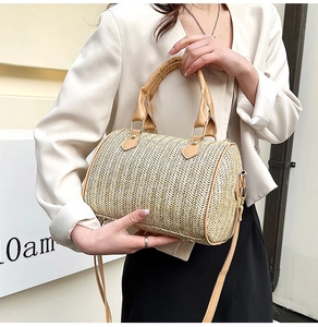 Vue détaillée du sac cylindre en paille tressée avec garniture en cuir PU brun et dorures