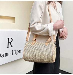 Détail d'un sac cylindrique tissé avec poignées en similicuir et clous de fond en métal