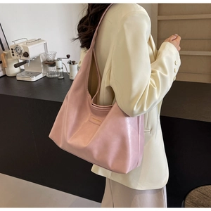 Pink PU leather shoulder hobo bag shown on a model in a cozy cafe setting