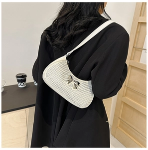 Detail of white PU leather baguette bag featuring sparkling rhinestones and silver metal bow