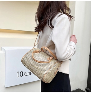 Détail du sac Boston en paille tressée avec bordure en cuir marron clair et bandoulière
