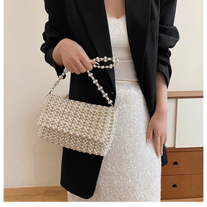 Detail of elegant handmade pearl beaded handbag with matching shoulder chain strap
