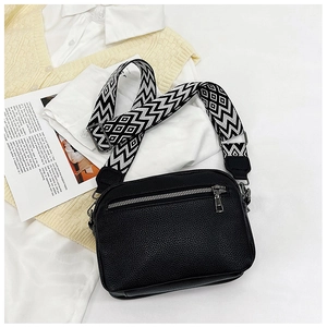 Détail du sac bandoulière noir grainé avec une sangle aux motifs géométriques