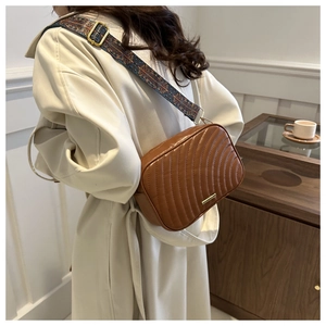 Close-up of brown quilted PU crossbody bag with bohemian print shoulder strap