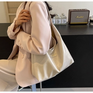 Minimalist beige PU leather tote bag shown in a lifestyle scene with high-quality texture