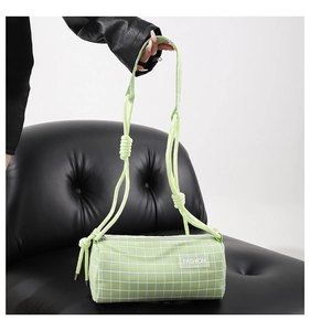 Détail du sac cylindre en nylon vert clair à carreaux avec nœuds en corde et zip