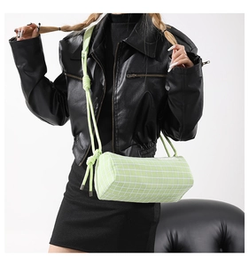 Détail du sac barillet vert clair à carreaux avec grille blanche et bandoulière en corde