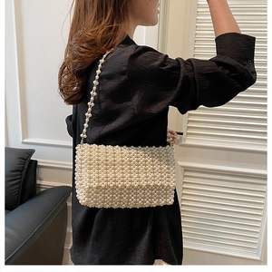 Detail of hand-woven cream pearl beads on a chic crossbody bag for dinner parties