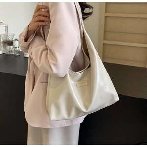 Detail of a beige glossy PU leather tote bag with a comfortable wide shoulder strap