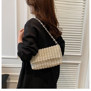 Close-up of elegant pearl beaded crossbody bag showing woven texture on a model
