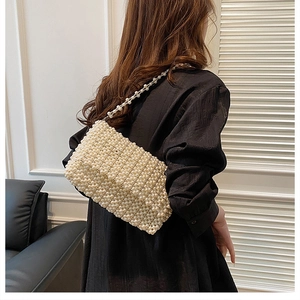 Detail of elegant cream white woven pearl handbag with refined beadwork texture