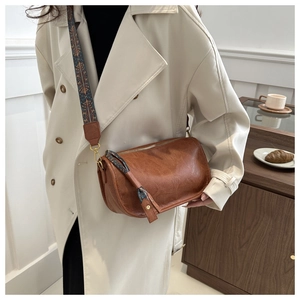 Gros plan d'un sac bandoulière en cuir PU marron avec sangle ethnique et boucles dorées vintage