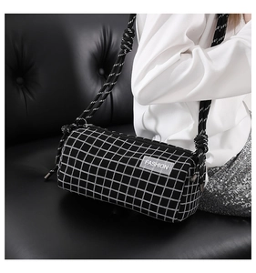 Détail du sac barillet à carreaux avec bandoulière en corde tressée et étiquette
