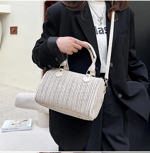Détail du sac Boston crème avec texture tissée en V et boucles métalliques dorées