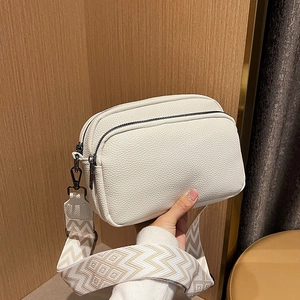 Sac caméra blanc minimaliste avec large bandoulière tissée géométrique et double fermeture