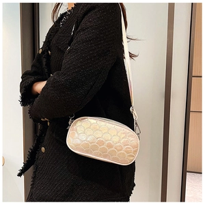 Detail of a champagne PU leather crossbody bag with scale stitching and a metal chain strap