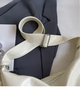 Dettaglio della tracolla regolabile in pelle PU con fibbia in metallo argento su borsa beige