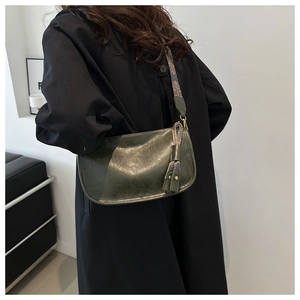 Détail du sac demi-lune vert foncé avec bandoulière large en tissage ethnique