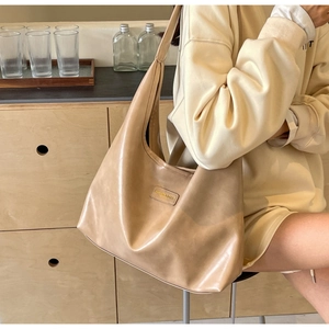 Detail of warm khaki PU leather tote bag with Fashion & Bags metal logo plate