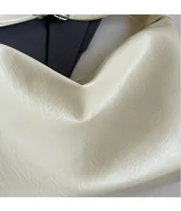Dettaglio della borsa a tracolla color crema in PU con trama a pieghe e fibbia in metallo
