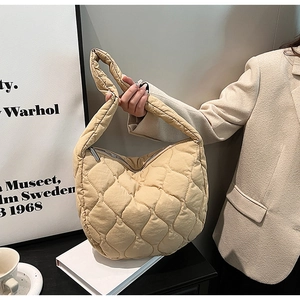 Detail of beige quilted nylon cloud hobo bag with padded texture and zipper closure