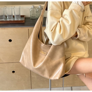 Close-up of khaki PU leather hobo bag with Fashion & Bags logo patch for daily commuting