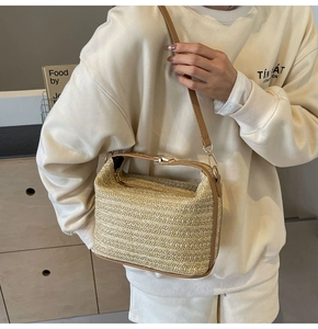 Dettaglio della trama in paglia intrecciata e delle finiture in pelle marrone della borsa