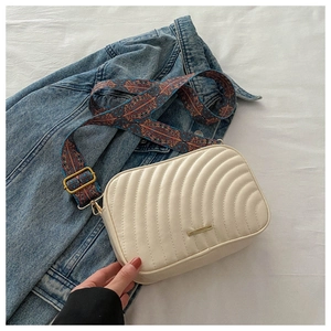 Off-white PU leather crossbody bag with wave quilting and ethnic geometric strap