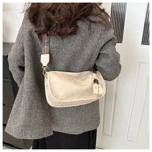 Détail du sac bandoulière beige en similicuir avec bandoulière brodée de style ethnique