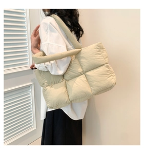 Détail du sac cabas matelassé beige porté par un mannequin en nylon léger et doux