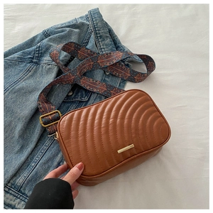Brown PU leather crossbody bag with quilted pattern and colorful geometric woven strap