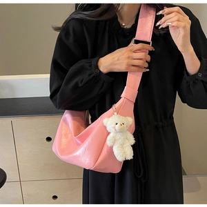 Borsa a tracolla a mezzaluna in pelle PU rosa con ciondolo a forma di orsetto su modella