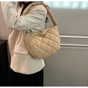 Detailed close-up of beige quilted crescent nylon handbag with elegant rhombus pattern