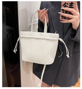 Detailed macro view of white pleated PU leather handbag with drawstring closure design