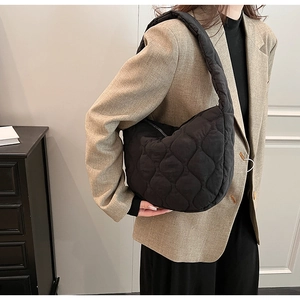 Detail view of black quilted nylon cloud bag with large diamond stitching texture