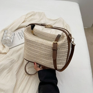 Borsa di paglia alla moda con manici in pelle marrone e dettagli dorati su fondo bianco