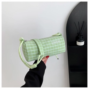 Sac cylindrique vert clair minimaliste avec motif à carreaux blancs et étiquette mode