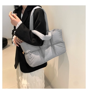 Gros plan détaillé d'un sac cabas matelassé gris clair porté par un mannequin en hiver