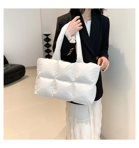 Détail du sac cabas matelassé blanc montrant le tissu rembourré et les coutures