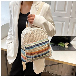 Close-up of woven straw backpack with colorful stripes worn by a model in a suit