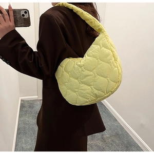 Close-up of lemon yellow quilted nylon crescent bag with textured puffy surface