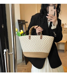 Close-up of retro woven handbag featuring a unique bamboo handle and textured beige pattern